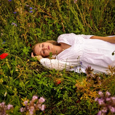 Frau liegt auf Blumenwiese
