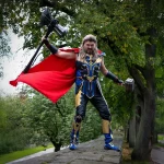 Chris in Thor-Kostüm mit rotem Umhang steht auf der Stadtmauer und hält zwei Hämmer in erhobenen Händen; Cosplay-Fotoshooting