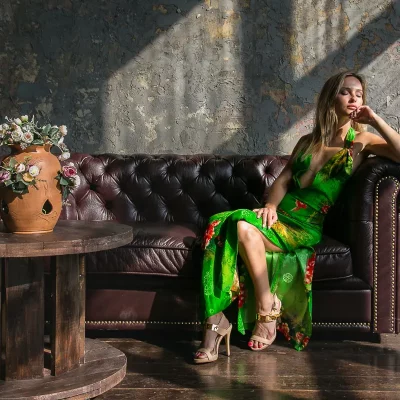 Frau in grünem Kleid auf einem alten Sofa