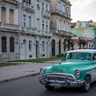 Grüner Oldtimer und spielende Kinder auf Kuba
