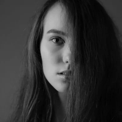 Frau, bei der die Haare eine Gesichtshälfte verdecken