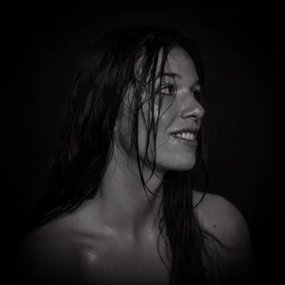 Schwarz-weiß-Portrait einer Frau mit nassen Haaren, die zur Seite blickt, mit freier Schulteransicht