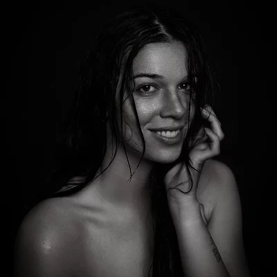 Schwarz-weiß-Portrait einer Frau mit nassen Haaren, die eine Hand an die Wange hält - TFP Fotoshooting