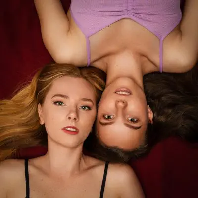 Zwei Frauen liegen auf einer Decke, Kopf an Kopf