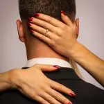 Frauenhände am Nacken eines Mannes