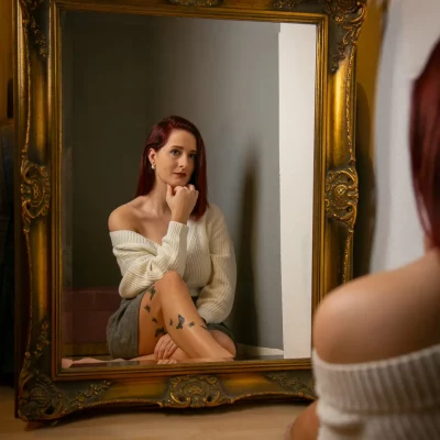 Frau sitzt vor einem Spiegel