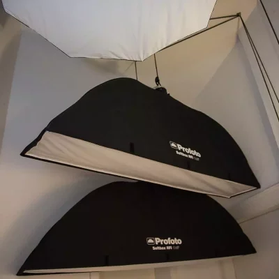 Drei große Profoto-Softboxen mit schwarzem Bezug und weißer Innenfläche hängen nebeneinander im Flur.