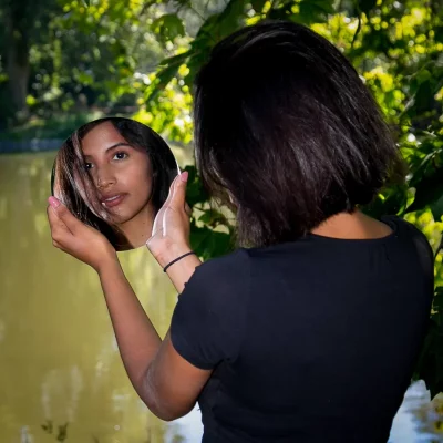 Frau mit Spiegel vor See