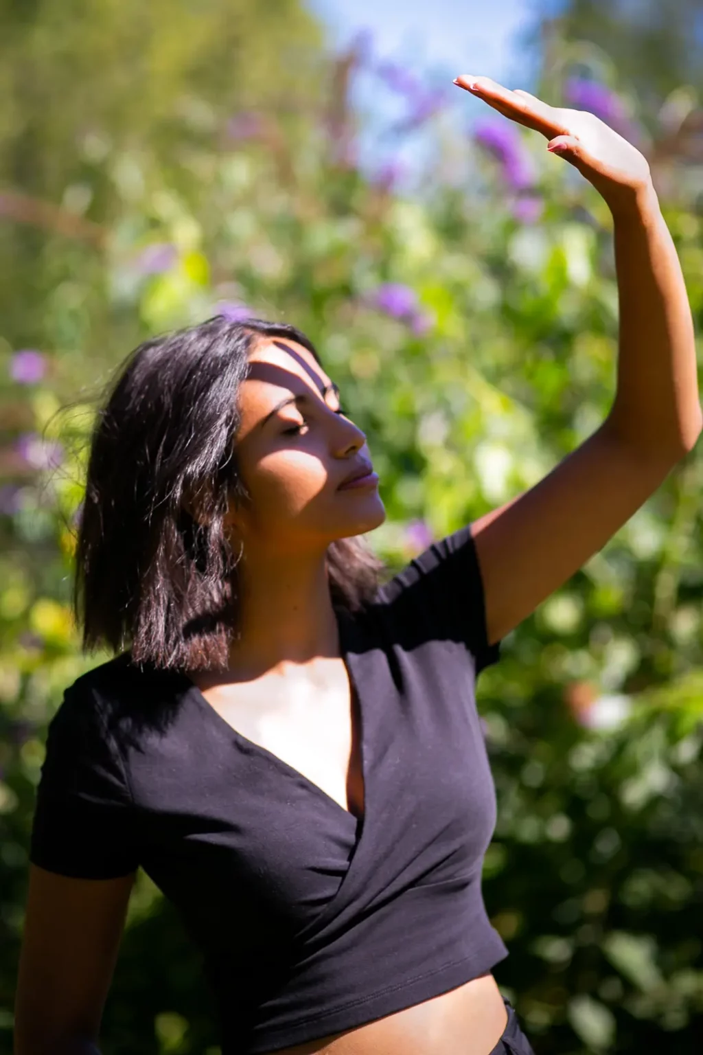 Frau hält Hand in die Sonne