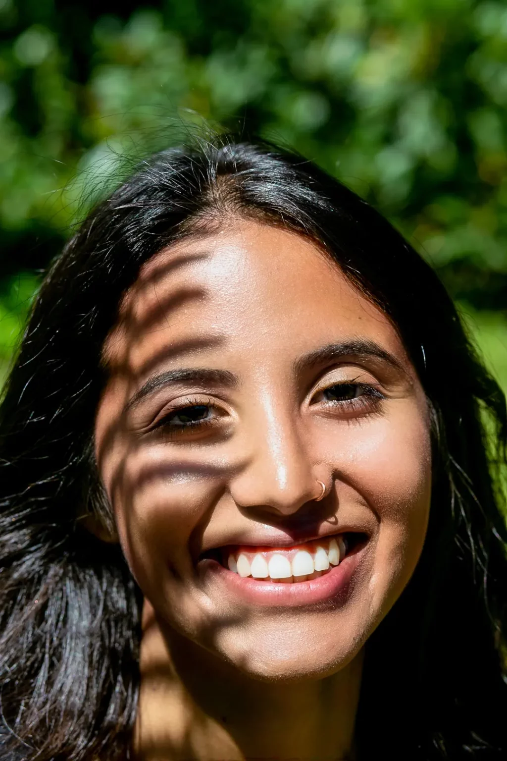 Frau lächelt mit Farn Schatten im Gesicht