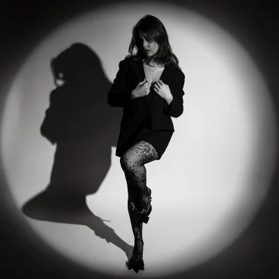 Schwarzweiß Fotoshooting im Studio mit Spotlicht – Model mit Netzstrumpfhose im Lichtkegel